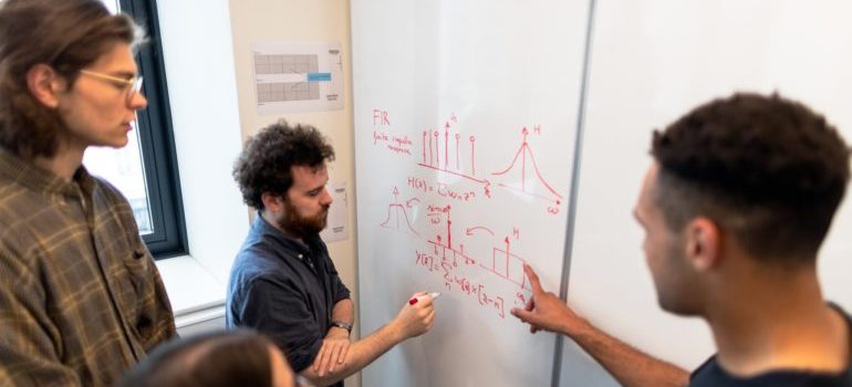 People looking at calculations on whiteboard