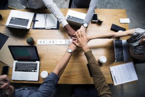 Hands in teamwork and planning with a common goal to develop and build your small business into something bigger.