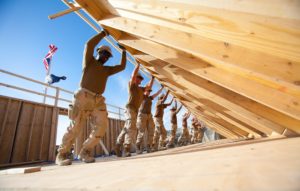 Team of soldiers building a montage home together.