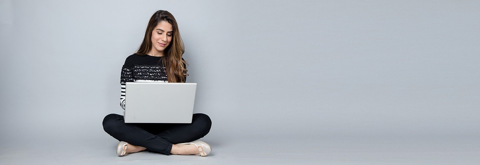 Woman sitting cross-legged and exploring websites and pages.