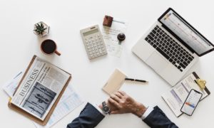 Laptop, newspaper, calculator, plans - everything you need on a table.
