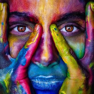 Girl with her face painted in different colors.