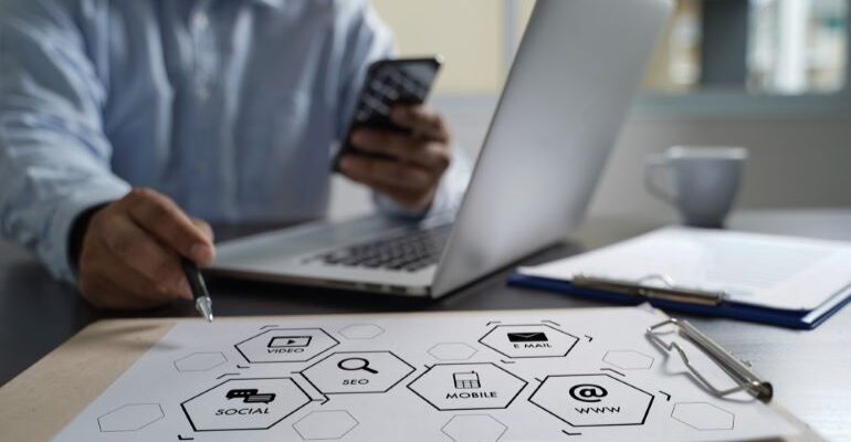 Person with phone and laptop, making a website optimization plan.