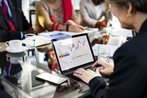 Person surrounded by team, looking at growth charts.