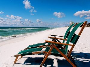 Two empty chairs on a beach.