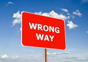 A red board with wrong way written on it which symbolizes link building mistakes
