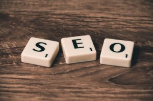 Word blocks spelling SEO on a wooden surface - organic SEO vs PPC