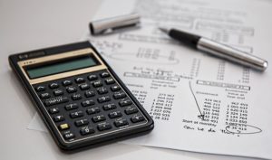 Calculator next to a paper with financial calculations.