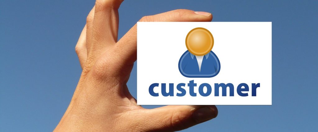 Hand holding a business card with CUSTOMER