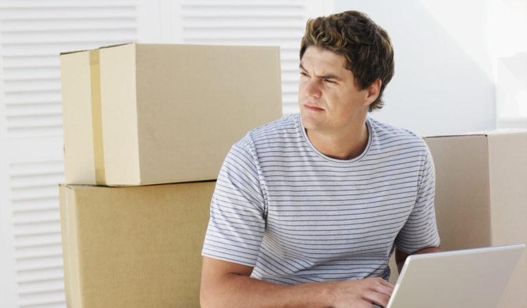 Person surrounded by moving boxes