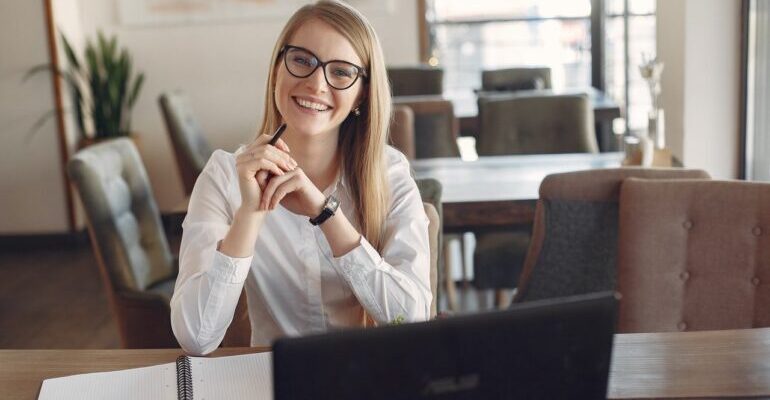 Woman sitting behind a laptop, smiling