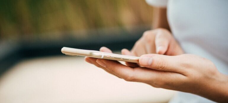 A woman's hand holding a smartphone.