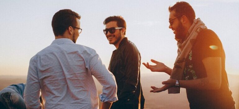 Three men standing outside and laughing.