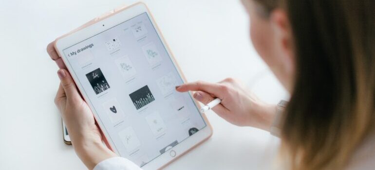 Woman looking at drawing pad, with different logo design ideas.