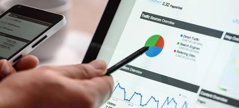 A person holding a pen over a pie chart on traffic sources.