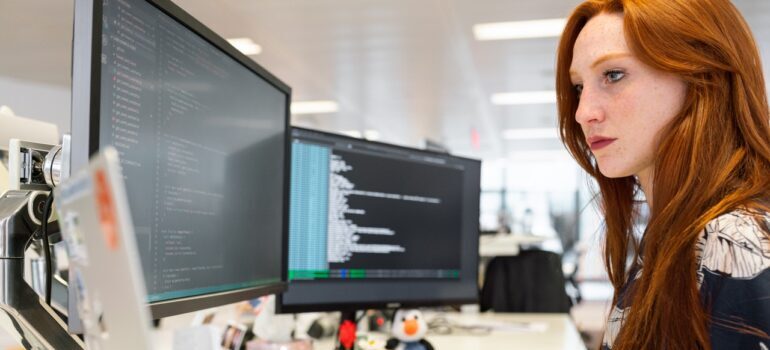 A woman looking at multiple screens