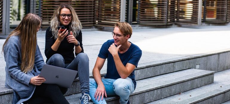 Young people in front of a library, talking about Snapchat marketing tips for businesses.