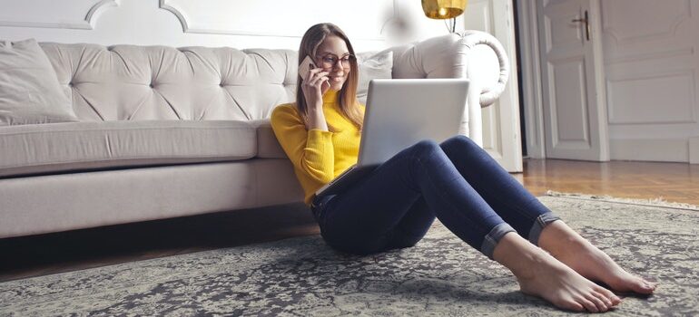 Person on the phone, using a laptop.