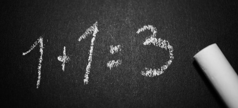 1+1=3 written on a chalkboard.