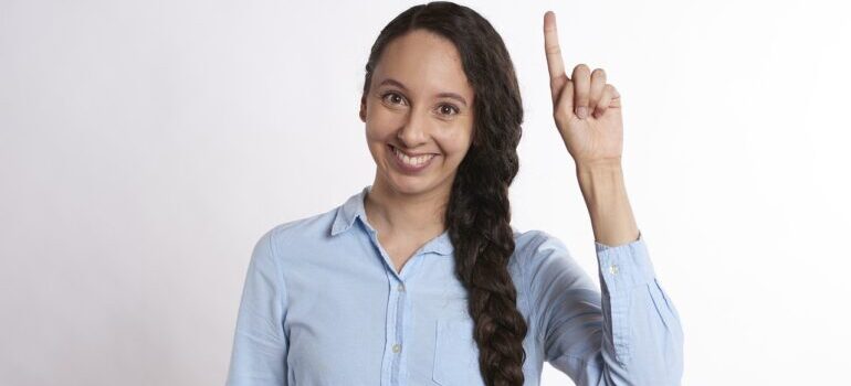 A woman pointing above her head.