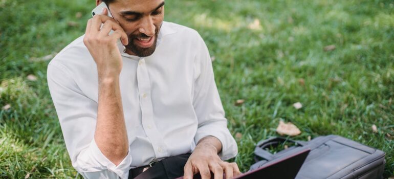 a man using a phone and a laptop
