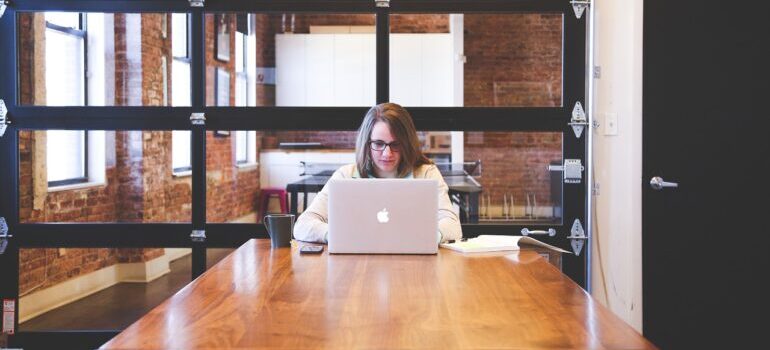 A woman working on a laptop in an office, reading about balancing SEO with quality content.