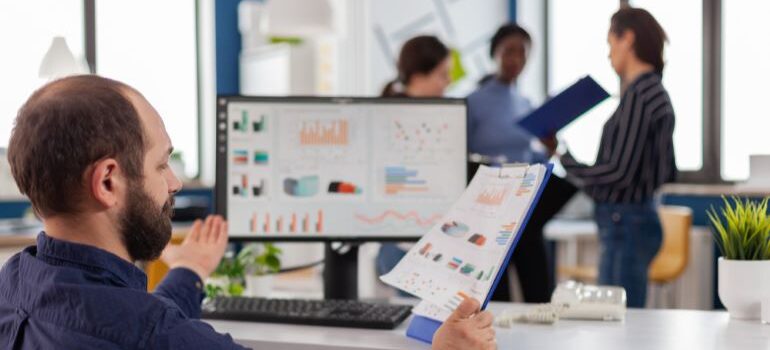 Person looking at charts in hand and on screen.
