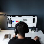 Person using a computer with two screens to plan our a way to grow your brand with SEO.